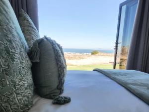 a bed with pillows with a view of the ocean at Black Eagle's Rest #Unit 1-8 in Langebaan +78 photos