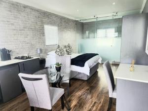 a bedroom with a bed and a table and chairs at Black Eagle's Rest #Unit 1-8 in Langebaan