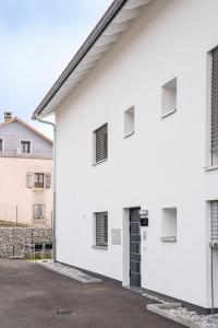 ein weißes Gebäude mit einer schwarzen Tür und Fenstern in der Unterkunft Semsales, relaxing and quiet in Semsales