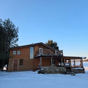 a log house in the snow with a balcony at Sodyba Pas Juzi in Alanta +8 photos