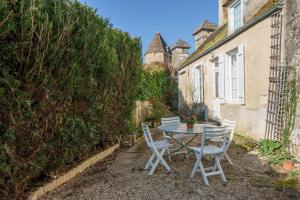 a table and chairs in the courtyard of a house at L'Avallonnaise - Au cœur de la Bourgogne in Avallon