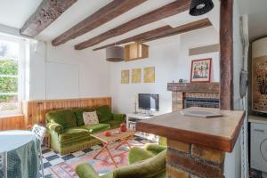 a living room with a green couch and a fireplace at L'Avallonnaise - Au cœur de la Bourgogne in Avallon +6 photos