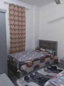 a small bedroom with two beds and a curtain at شقة فاخرة خلف الاستاد اسوان in Aswan