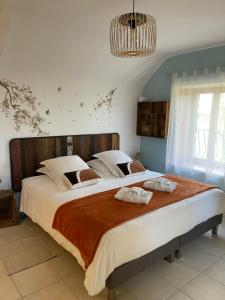 a bedroom with a large bed with two towels on it at Le Haut Pont de la Baie in Mont-Dol