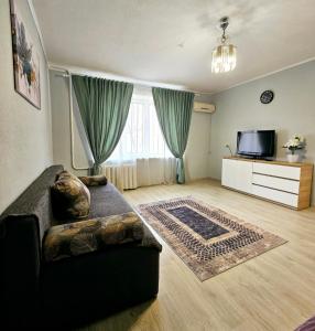 ein Wohnzimmer mit Sofa und Fernseher in der Unterkunft Уютная квартира на Тверская 5, пр Правды, клиника Рохманова in Dnipro