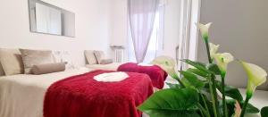 - 2 lits avec des couvertures rouges dans une chambre dans l'établissement Appartamento vicino al centro Adigeo e fiera, à Vérone
