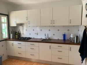a kitchen with white cabinets and a counter top at Casa Myjoli in Vinaròs +9 photos