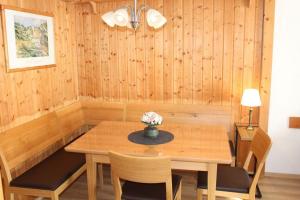 Ferienhaus Nr 121, Kategorie Komfort, Feriendorf Hochbergle, Allgäu في Karlsebene: غرفة طعام مع طاولة وكراسي خشبية