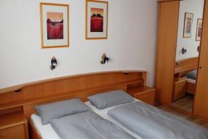 Ferienhaus Nr 121, Kategorie Komfort, Feriendorf Hochbergle, Allgäu في Karlsebene: غرفة نوم بها سرير ووسادتين