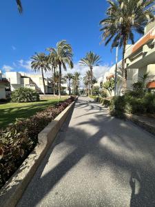 eine leere Straße mit Palmen und einem Gebäude in der Unterkunft Apartamento costero Atardecer dorado in Las Galletas + 12 Fotos
