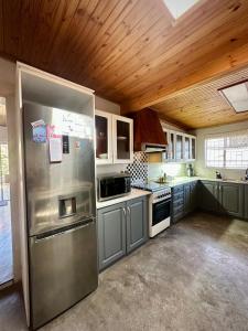 a large kitchen with a stainless steel refrigerator at Mario & Luiza's Place - Cozy Stay with Pool & Braai in Worcester