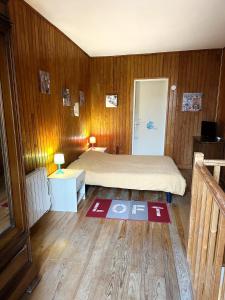 a bedroom with a bed and a wooden wall at maison de tourisme aux sables d'olonne in Les Sables-dʼOlonne