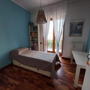 a bedroom with a bed and a book shelf and a window at Casa Melina in Nola