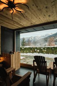 a dining room with a large window with a mountain view at Boutique Hotel e Chalets Salvadori in Mezzana +121 photos
