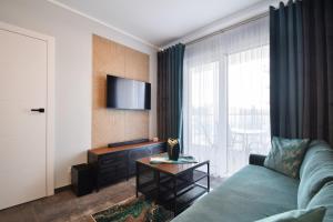 a living room with a couch and a tv at RentPlanet - Perłowa Przystań in Sianozety