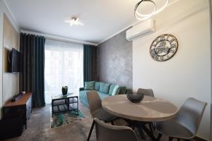 a living room with a table and a blue couch at RentPlanet - Perłowa Przystań in Sianozety