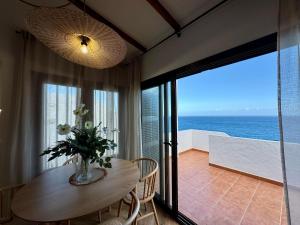 a dining room with a table and a view of the ocean at Vera Beach House in Maspalomas
