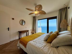 a bedroom with a bed with a ceiling fan at Vera Beach House in Maspalomas