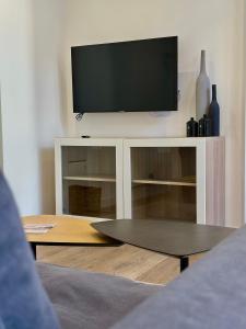 una TV a schermo piatto in cima a un centro di intrattenimento bianco di CoruñaFlat Apartments - Centro A Coruña a La Coruña Altre 45 foto