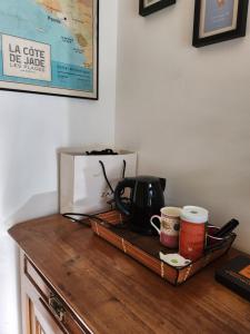 eine hölzerne Arbeitsplatte mit Kaffeemaschine und Kaffeetassen in der Unterkunft La Lectais in Romille