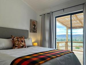 a bedroom with a bed and a large window at Sempurna Estate in McGregor