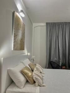 a bedroom with a bed with white and gold pillows at Banchi 28 by Arbaspàa in La Spezia
