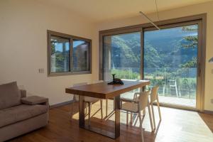 a dining room with a table and chairs and a large window at LA FORESTALE Luxury Ecolodge Piano Terra- Appt in Acqualagna