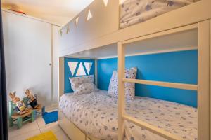 a bunk bed in a childs bedroom with blue walls at Manessy in Badesi +18 photos
