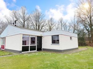 ein kleines weißes Haus mit einem grünen Hof in der Unterkunft Bungalowpark Simpelveld - Schakel 22 in Simpelveld
