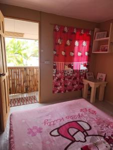 a room with a bed and a window with a rug at JFive Homes by the Sea in Lianga
