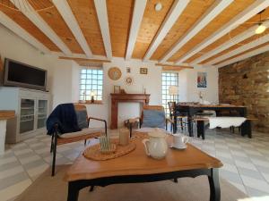 a living room with a table and a fireplace at Jolie maison en pierre avec grand jardin pour 6 in Guissény