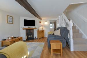 Il comprend un salon avec un escalier et une télévision. dans l'établissement Meadow View Cottage, à Exmouth