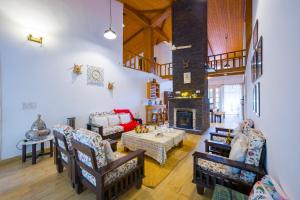 a living room with a table and a fireplace at Alaya Stays Country Ville - 3 BHK Pet Friendly Villa with Lush Garden & Kids Room in Kokliyal Gaon