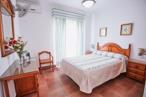 a bedroom with a bed and a table and a window at Hostal Azul in La Antilla