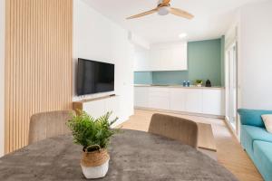 Una sala de estar con una mesa y un sofá azul. en Alojamiento Entero En Aguilas, en Águilas