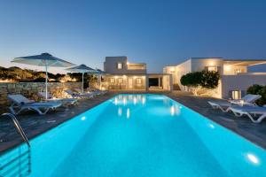Una piscina con sillas y sombrillas al lado de una casa. en Villa Dioni, en Santa Maria