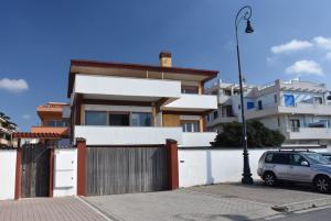 a house with a gate and a car parked in front at Mare e Relax 1 Melody Sea Front 10' da FCO Airport in Fiumicino