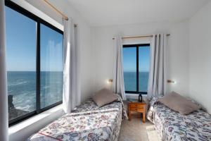 a bedroom with two beds and large windows at La Bayana Apartments - 5 in Puerto Naos +15 photos