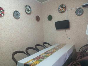 a room with a table and chairs and plates on the wall at Sohibqiron boutique in Bukhara