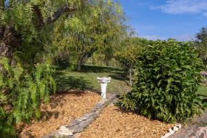 a garden with a statue in the middle of a yard at Monte dos Casarões- Casinha in Odemira