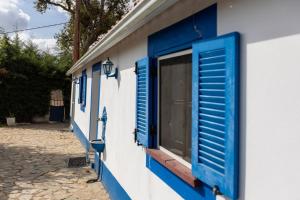 a blue and white building with blue shuttered windows at Monte dos Casarões- Casinha in Odemira +37 photos