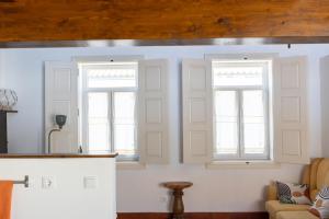 two windows in a living room with a couch at Casa Amarela Sao Luis in Odemira