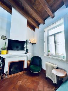 a living room with a fireplace and a green chair at Casa Amarela Sao Luis in Odemira