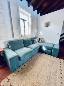 a blue couch in a living room with a window at Casa Amarela Sao Luis in Odemira
