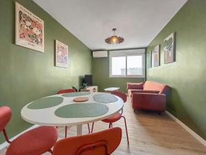 une pièce avec une table, des chaises et un canapé dans l'établissement Cosy T3 Plein Centre, Clim & Balcon, à Toulouse