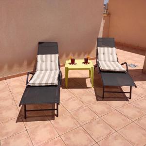 two chairs and a table in a room at Apartment with roof terrace, Mar de Cristal in Mar de Cristal
