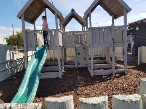 a boy on a slide in a wooden playground at 6 Berth Caravan with garden - Brightholme Holiday Park in Brean
