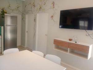 a kitchen with a table and a tv on a wall at Refugio de Soles in Cachí