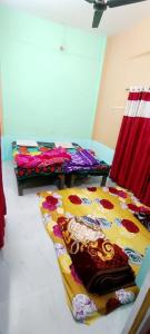 - 2 lits dans une chambre avec une couverture colorée dans l'établissement Bajrang kutirr, à Varanasi