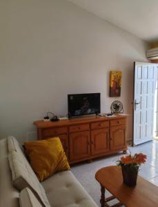 a living room with a couch and a flat screen tv at Sandy Bunker 2 bed apartment and pool in Alicante
